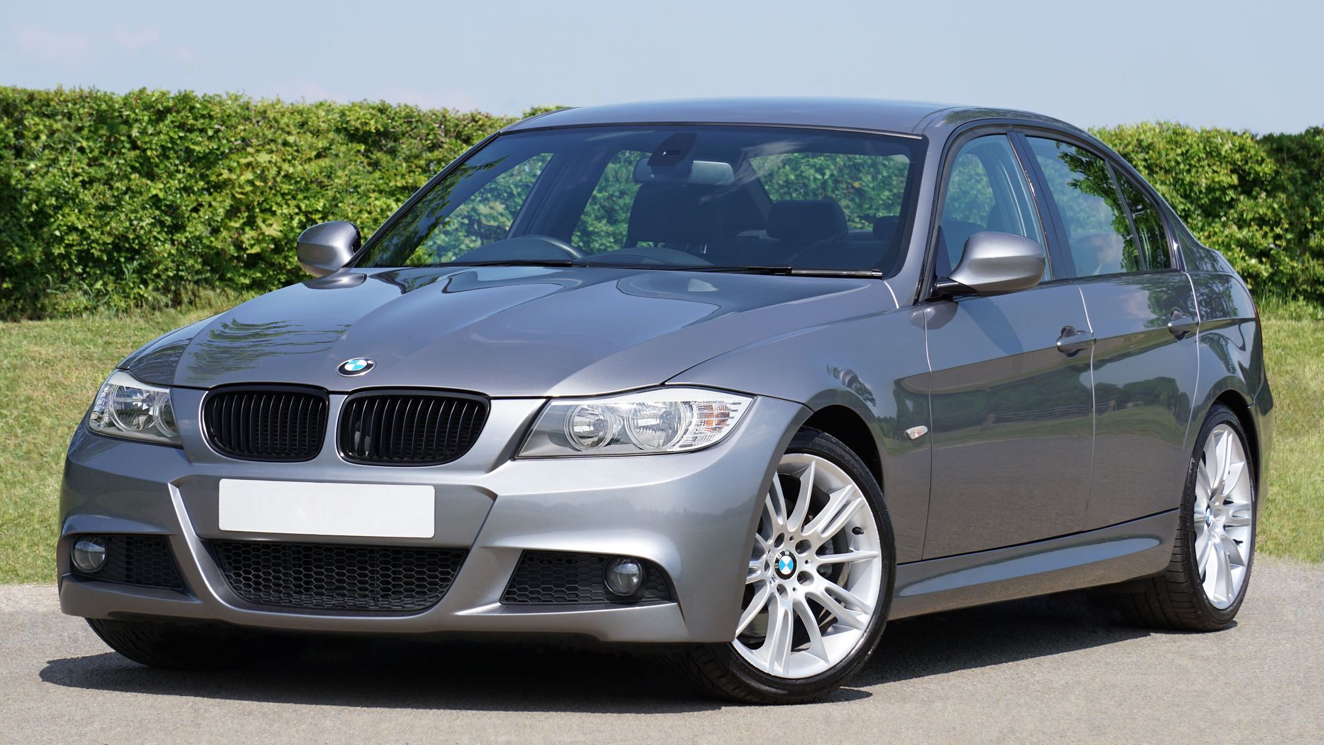 A sleek grey BMW sedan parked outdoors on a sunny day, showcasing modern automotive design.
